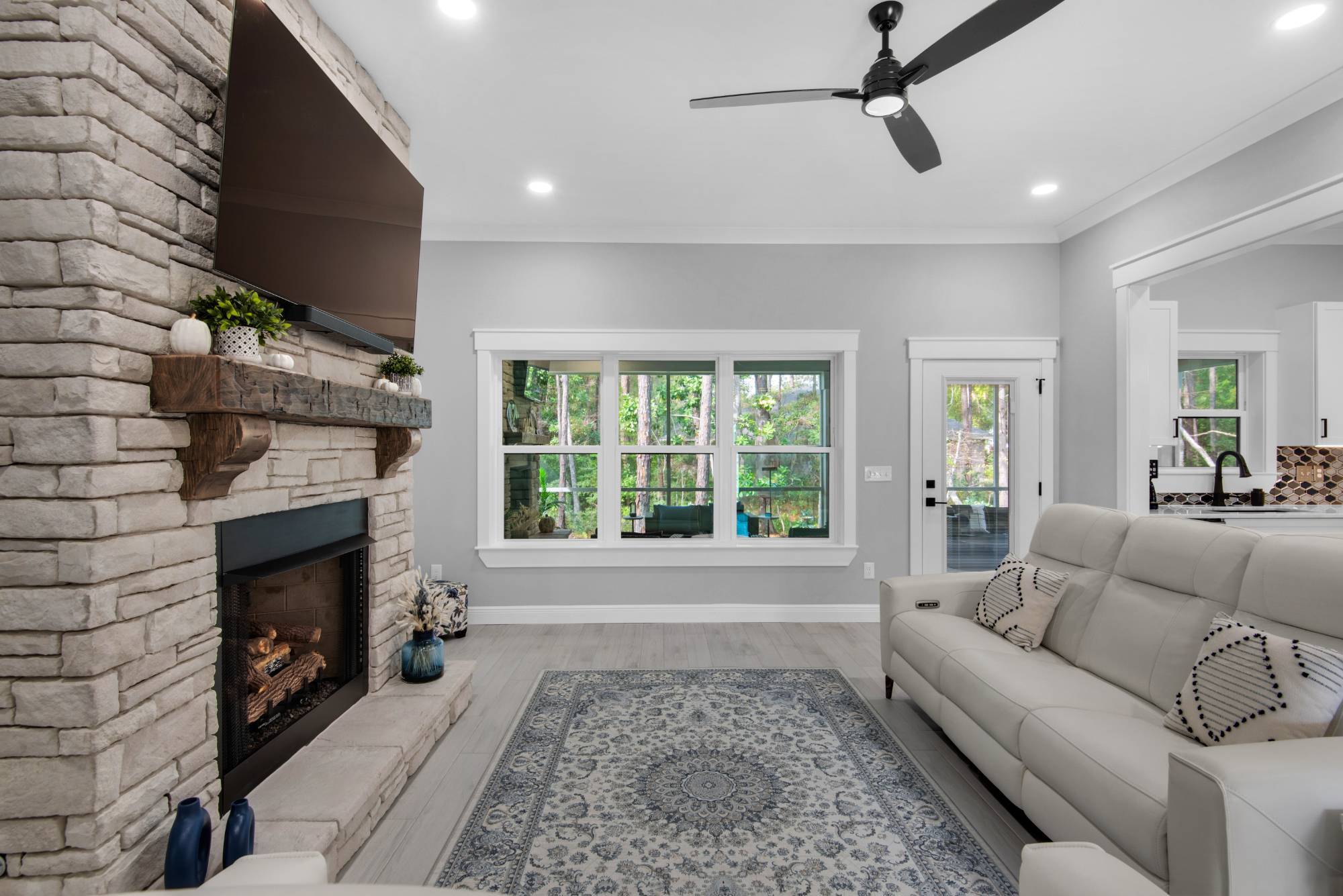 living room angle showing fireplace and large window view by EZ Modern Homes Pensacola FL The Lafon-optimized