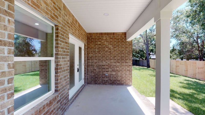 rear patio with brick walls and yard view by EZ Modern Homes Pensacola FL custom home The Abilene-optimized-optimized