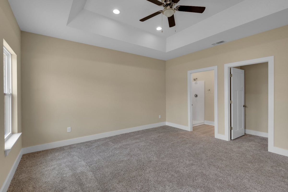 bedroom with ensuite bathroom and walk-in closet in EZ Modern Homes custom home Pensacola FL The Poderosa-optimized