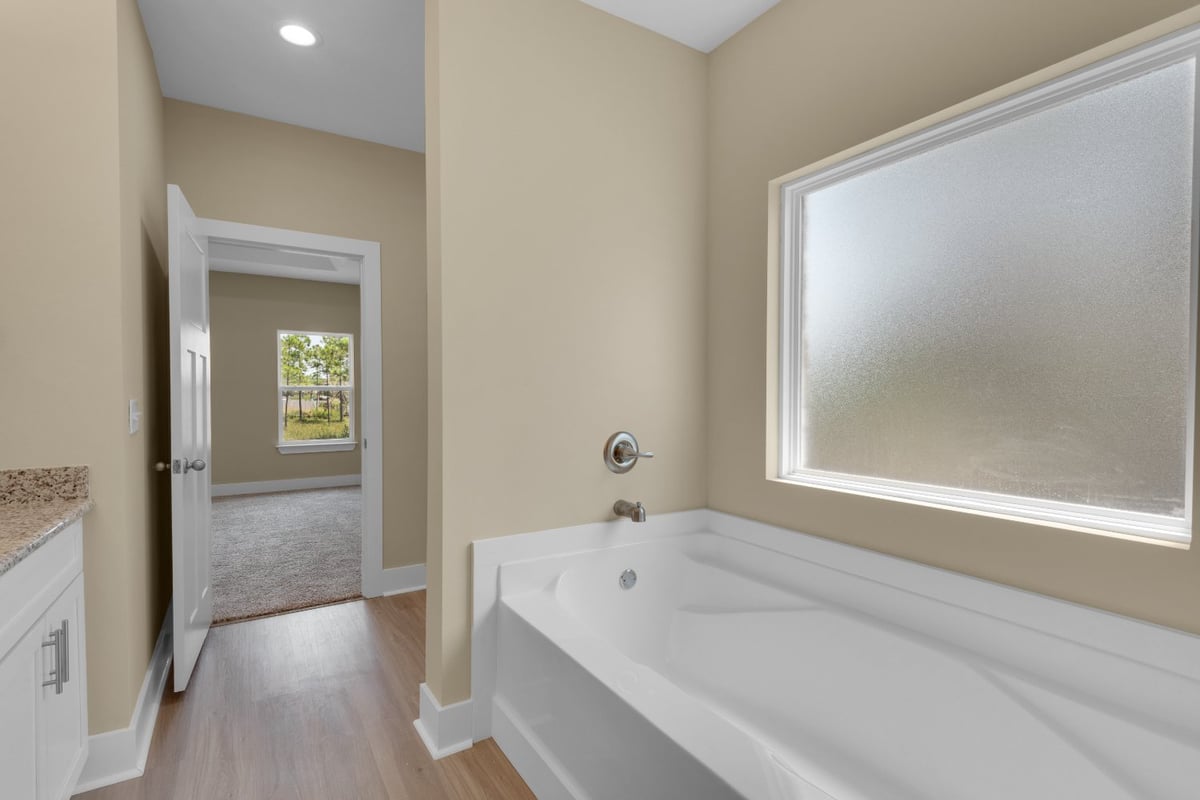 clean bathroom design with bathtub in Pensacola FL custom home by EZ Modern Homes The Poderosa-optimized