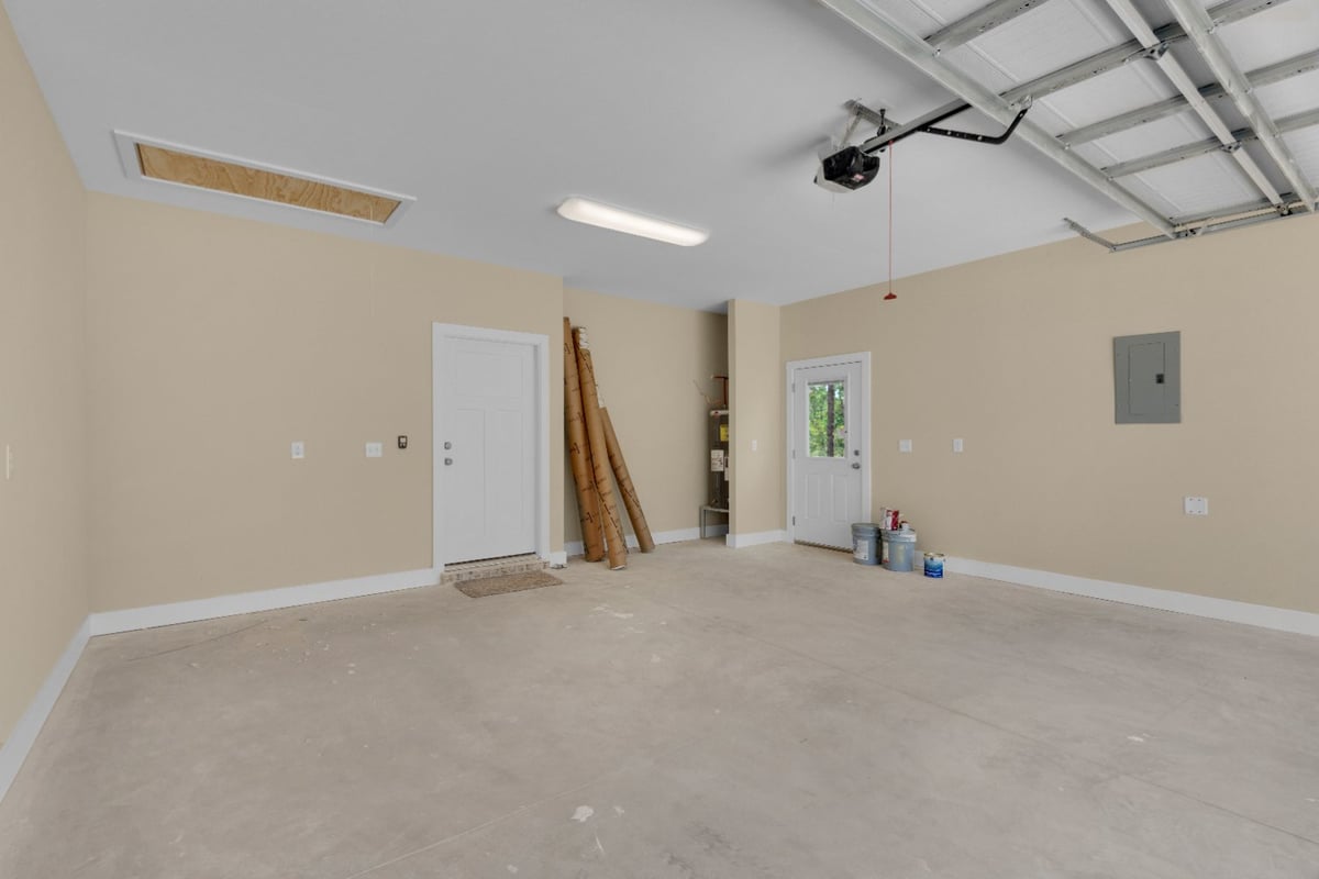 clean garage space with storage and access door in Pensacola, FL custom home by EZ Modern Homes The Poderosa-optimized