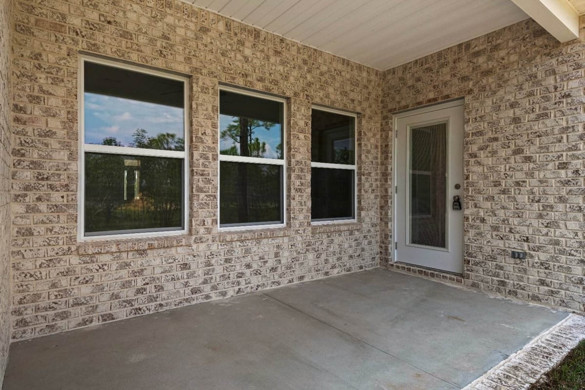 covered back patio with brick exterior in The Poderosa custom home by EZ Modern Homes Pensacola, FL-optimized-optimized