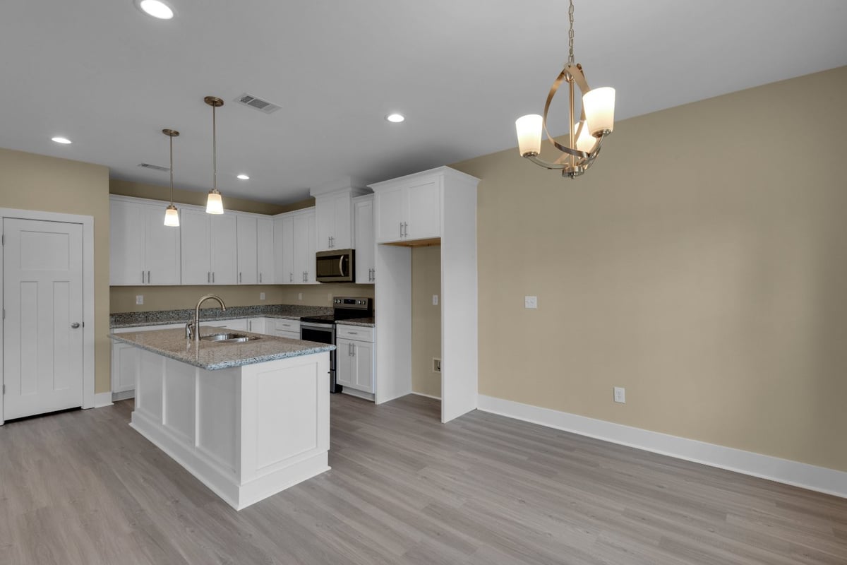 modern open-concept kitchen with white cabinets and granite island in custom home by EZ Modern Homes in Pensacola FL The Poderos-optimized