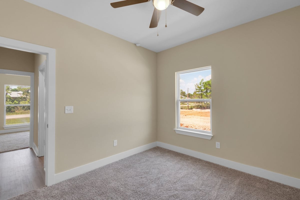 neutral-toned bedroom with plush carpet and natural light in Pensacola, FL custom home by EZ Modern Homes The Poderosa-optimized