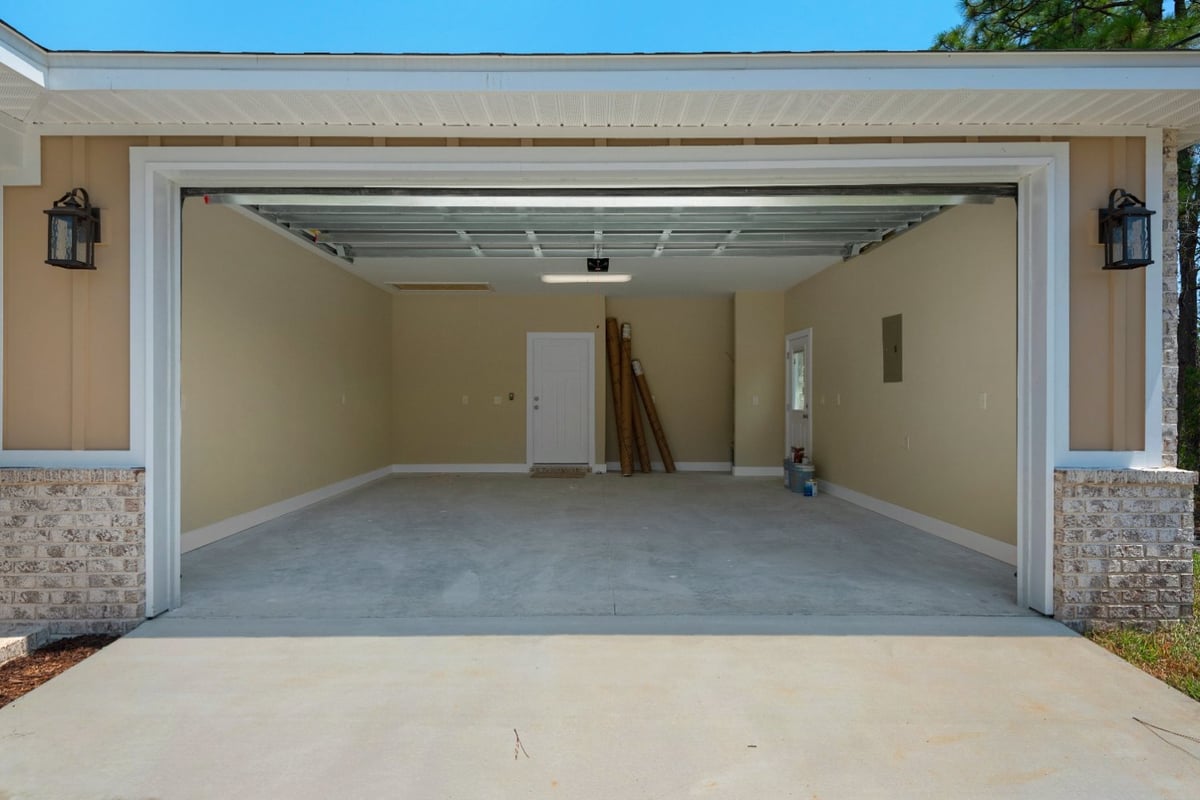 open garage exterior view of The Poderosa custom home by EZ Modern Homes in Pensacola, FL-optimized
