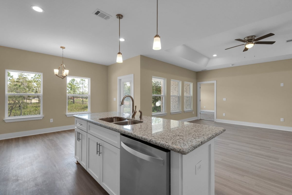 open living area with kitchen island and large windows in Pensacola FL custom home by EZ Modern Homes The Poderosa-optimized