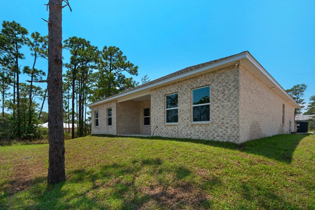 side exterior view of brick home in The Poderosa custom home by EZ Modern Homes Pensacola, FL-optimized-optimized