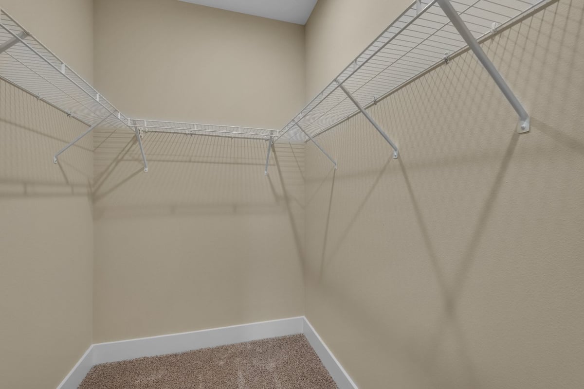 walk-in closet with wire shelving in Pensacola FL custom home by EZ Modern Homes The Poderosa-optimized