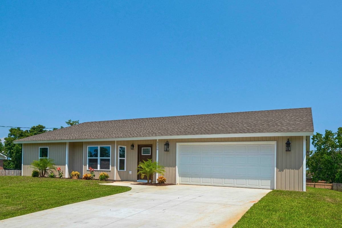 Angled view of custom home exterior with two-car garage by EZ Modern Homes Pensacola FL The Pins-optimized