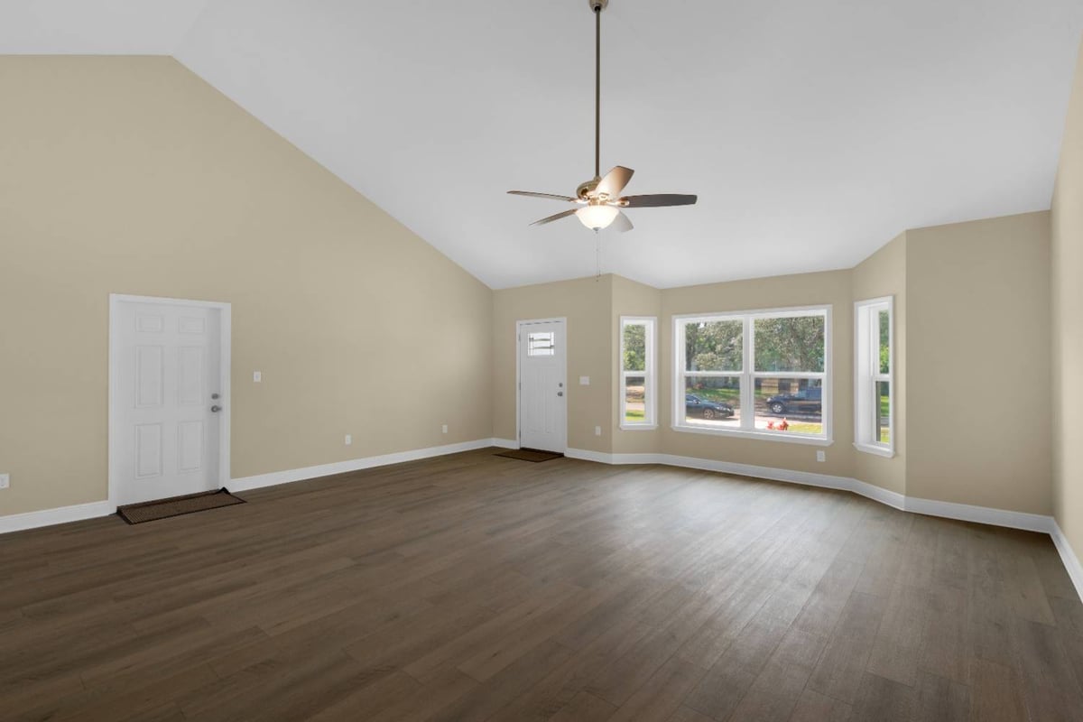Bright living room with large front windows in custom home Pensacola FL by EZ Modern Homes The Pins-optimized