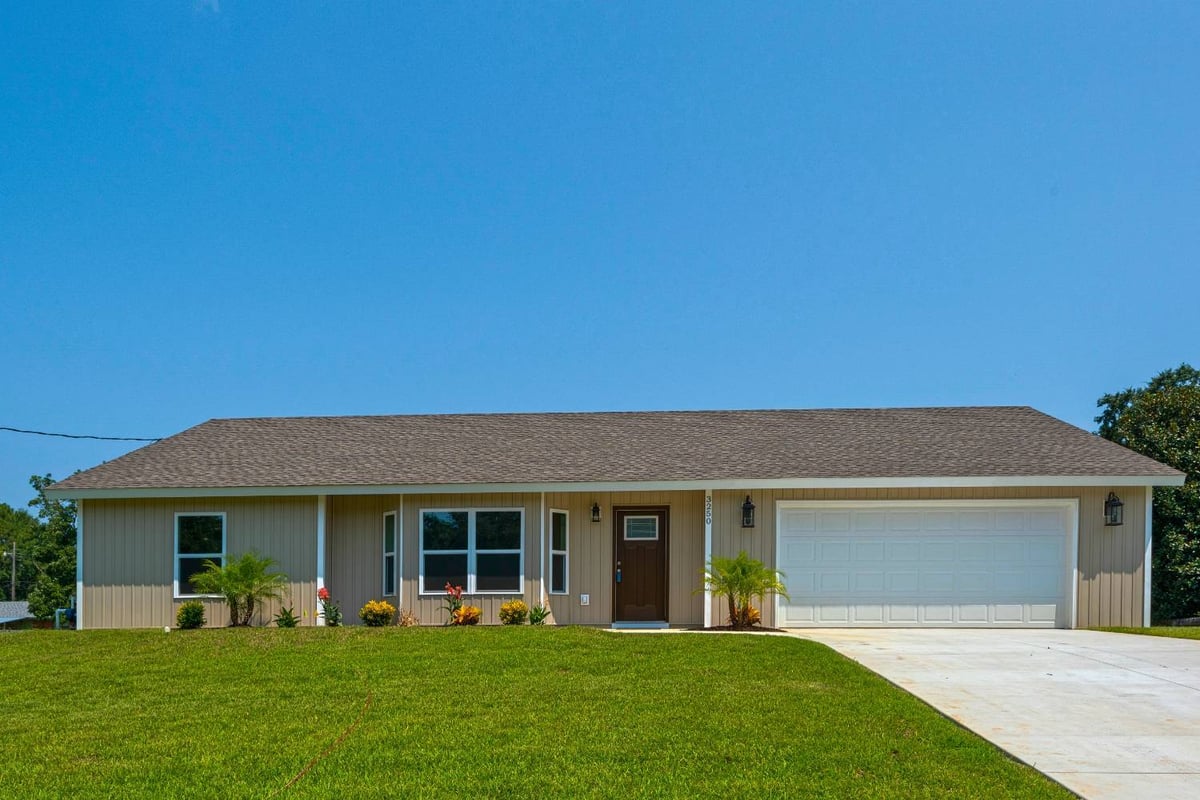 Front exterior of single-story custom home with garage by EZ Modern Homes in Pensacola, FL The Pins-optimized