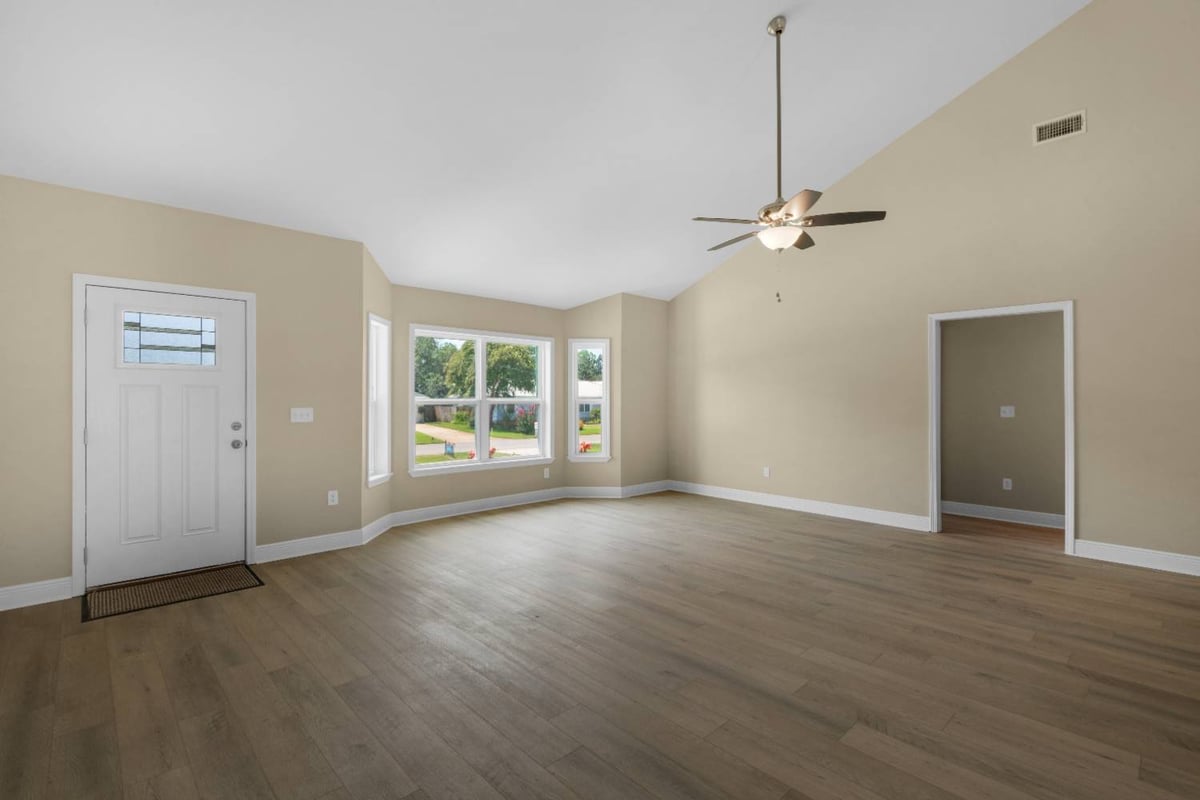 Living room with entry door and window seating area in Pensacola FL custom home The Pins-optimized