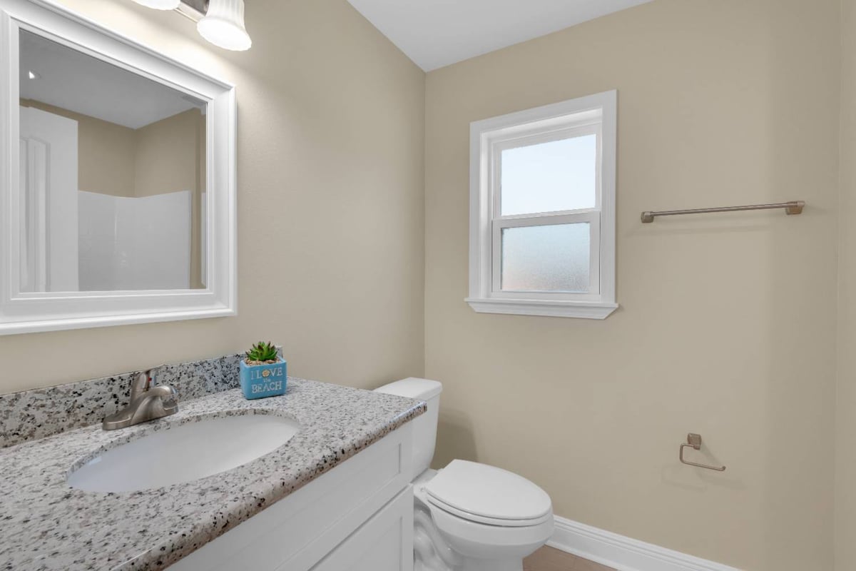 bathroom vanity with granite countertop and toilet in custom home by EZ Modern Homes in Pensacola, FL-optimized