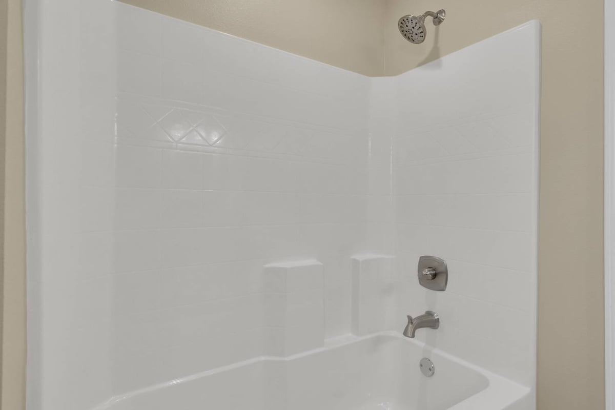bathtub and shower combo with white tile surround in custom home by EZ Modern Homes in Pensacola, FL-optimized