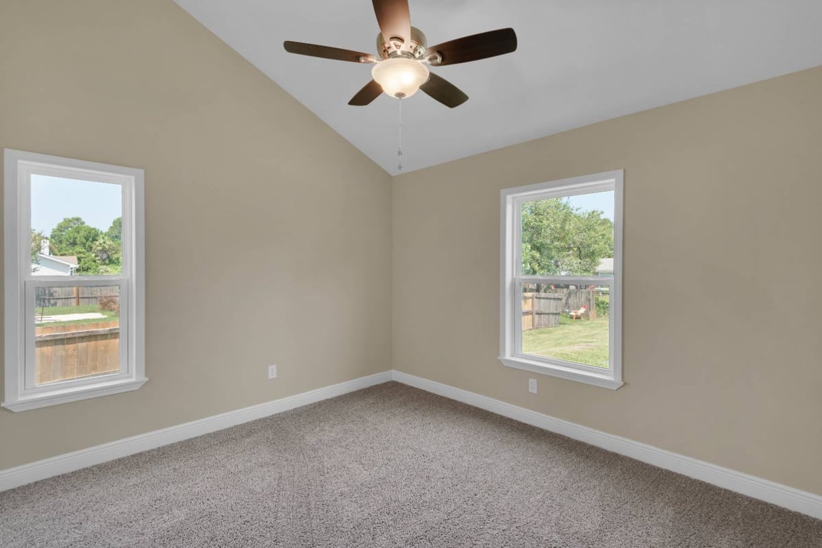 bedroom with dual windows and vaulted ceiling in custom home by EZ Modern Homes in Pensacola, FL-optimized