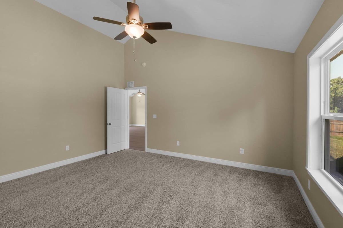 carpeted bedroom with high ceiling and doorway view in Pensacola custom home by EZ Modern Homes-optimized