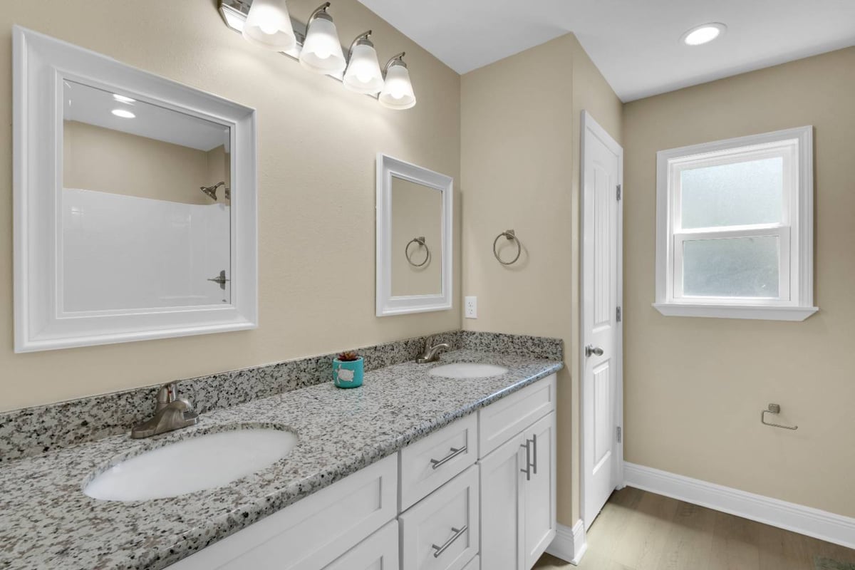 double vanity bathroom with granite countertops and modern lighting in custom home by EZ Modern Homes in Pensacola, FL-optimized