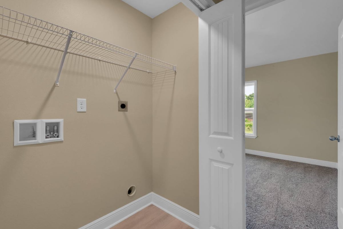 laundry room with shelving and washer dryer hookups in custom home by EZ Modern Homes in Pensacola, FL-optimized
