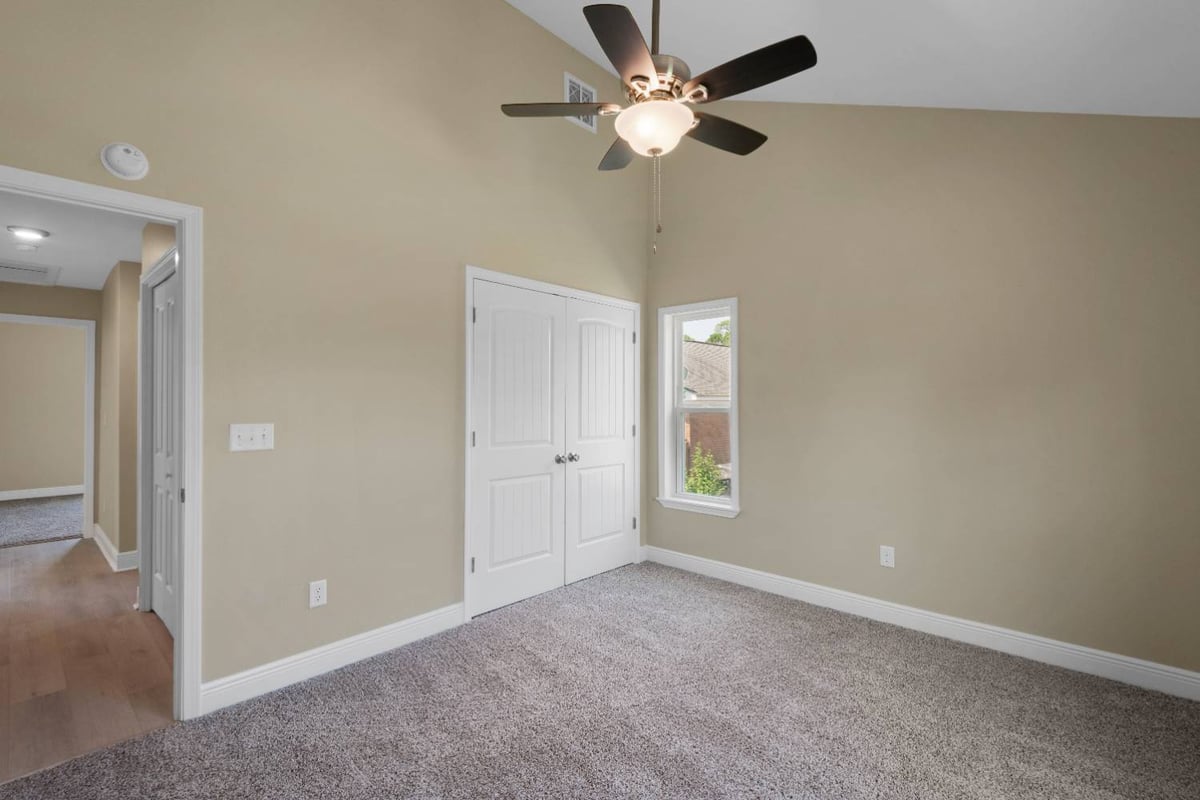 spacious bedroom with vaulted ceiling and natural light in Pensacola custom home by EZ Modern Homes-optimized