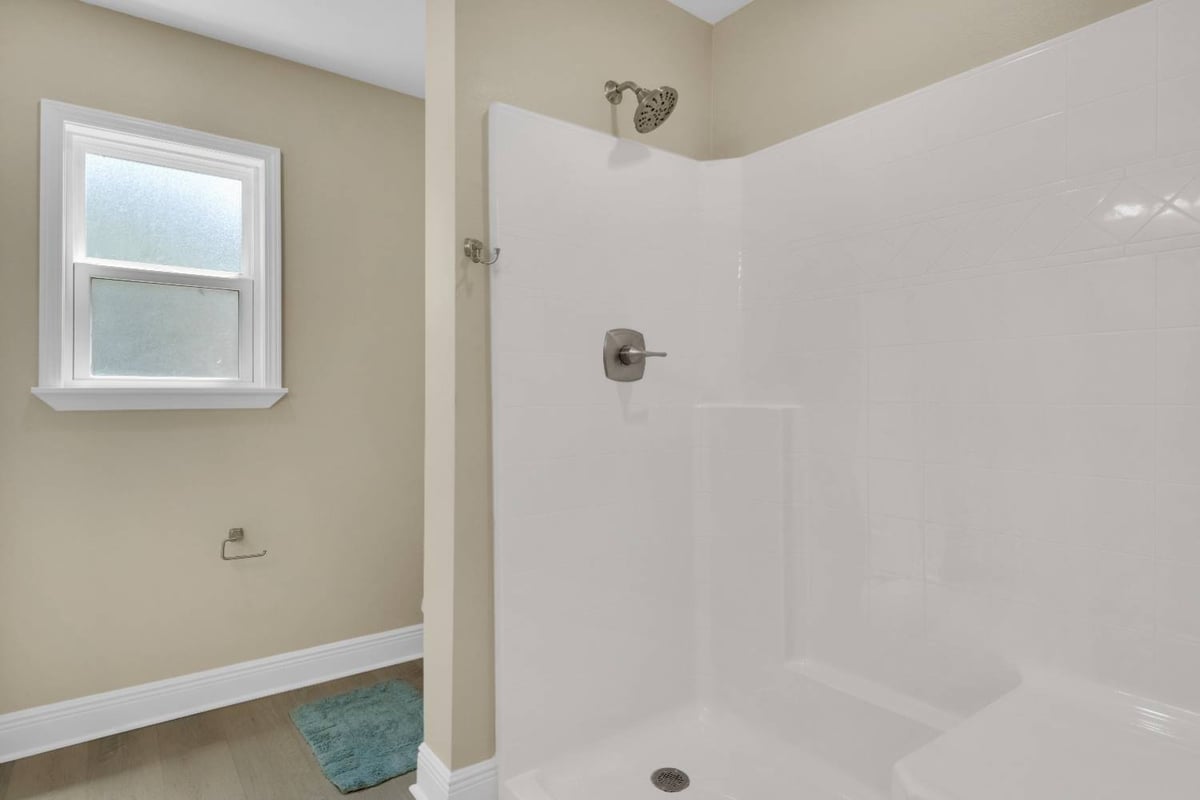 walk-in shower with white tile surround in custom home bathroom by EZ Modern Homes in Pensacola, FL-optimized