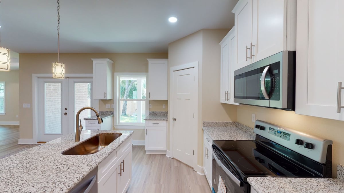 Kitchen close-up with granite countertops and appliances in a custom home by EZ Modern Homes in Pensacola, FL.-optimized