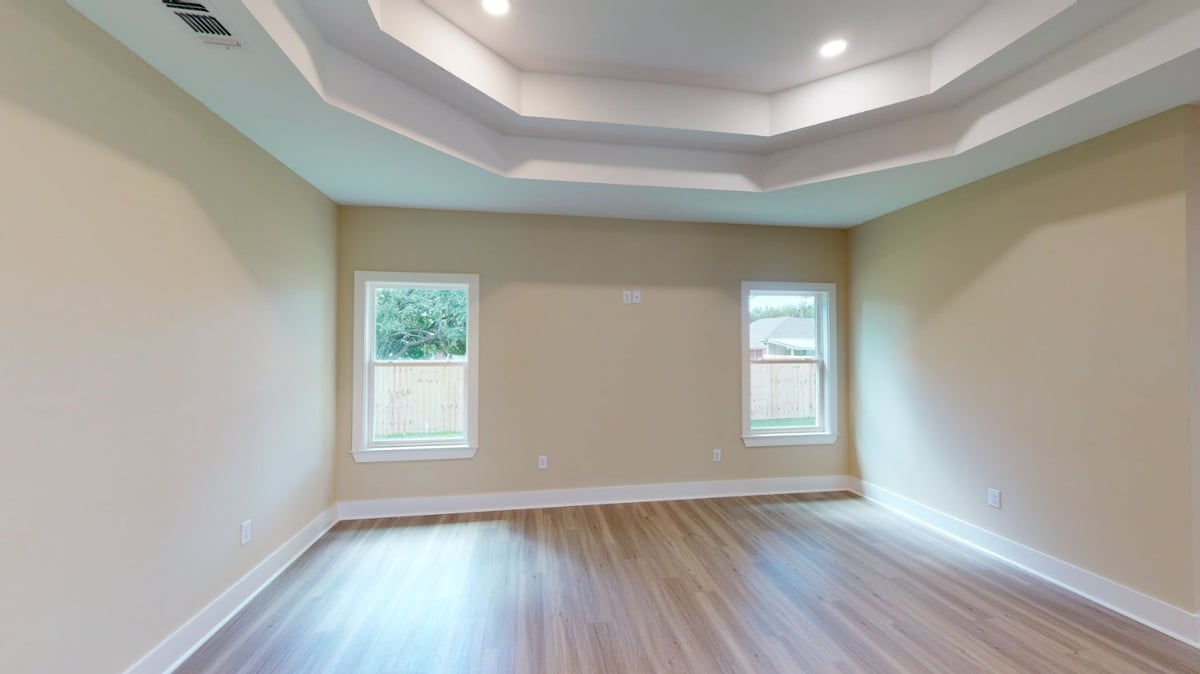 Living room with tray ceiling and large windows in a custom home by EZ Modern Homes in Pensacola, FL.-optimized