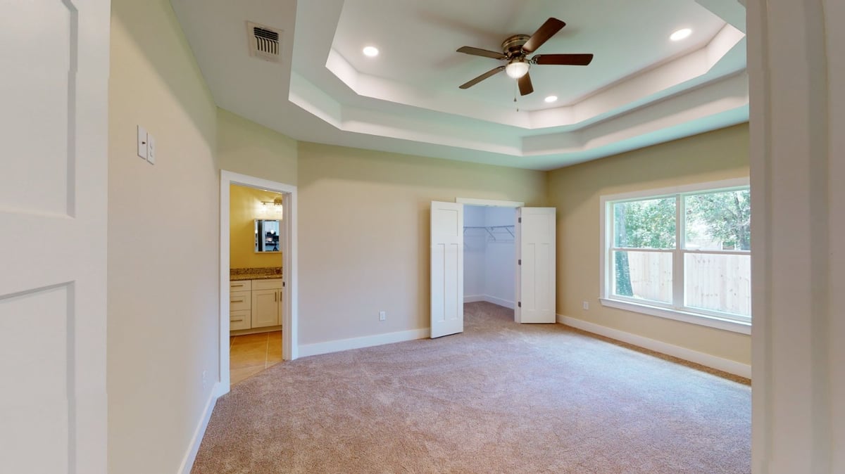 Spacious bedroom interior of a Pensacola, FL custom home by EZ Modern Homes with modern finishes and soft flooring.-optimized