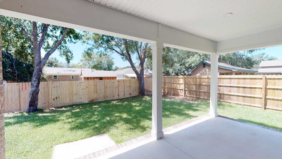 covered backyard patio with fenced lawn by EZ Modern Homes custom home Pensacola FL The Abilene-optimized