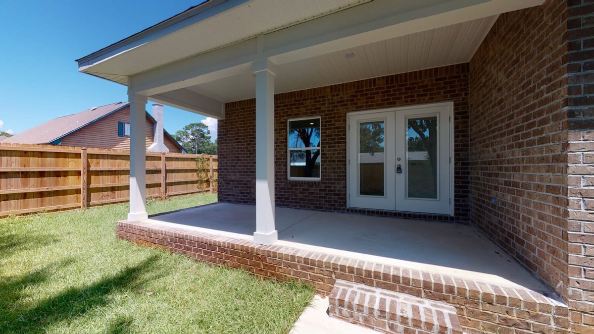 fenced backyard side elevation of home in Pensacola FL custom home by EZ Modern Homes The Abilene-optimized