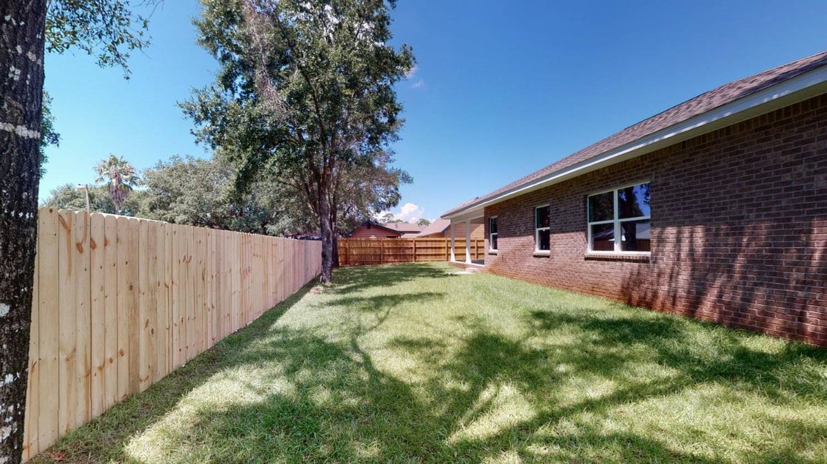 green backyard area with privacy fence in Pensacola FL custom home by EZ Modern Homes The Abilene-optimized-optimized