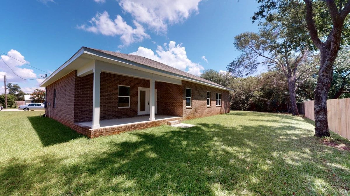rear exterior view with covered patio and yard by EZ Modern Homes custom home Pensacola FL The Abilene-optimized-optimized