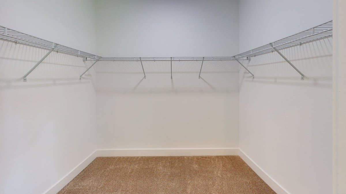 walk-in closet with wire shelving in custom home by EZ Modern Homes Pensacola, FL-optimized