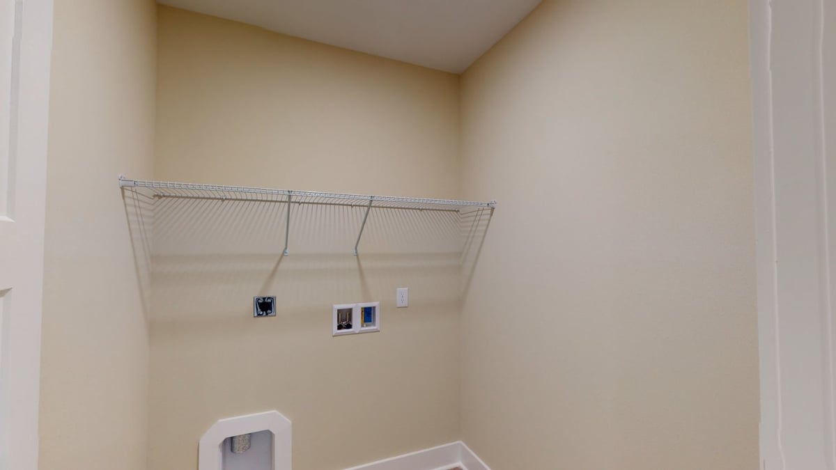 walk-in laundry room with shelving and hookups in EZ Modern Homes custom home Pensacola FL The Abilene-optimized