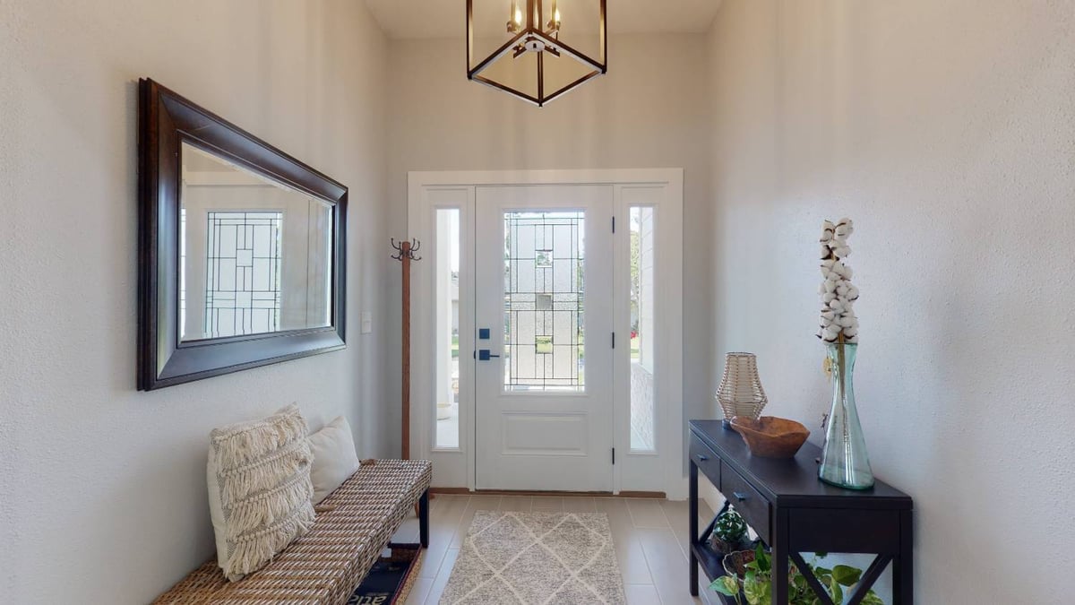Entry hallway of The Lafon custom home by EZ Modern Homes with glass door and bench in Pensacola, FL-optimized