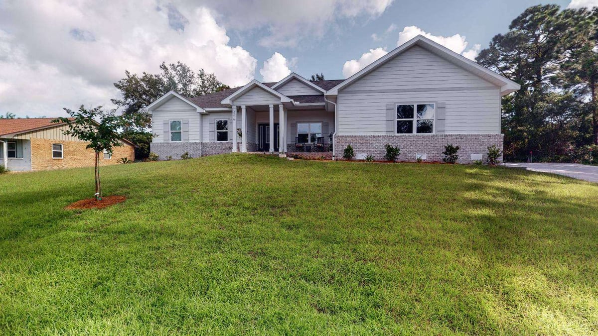 Front elevation of EZ Modern Homes custom home The Lafon with landscaped yard in Pensacola, FL-optimized-optimized