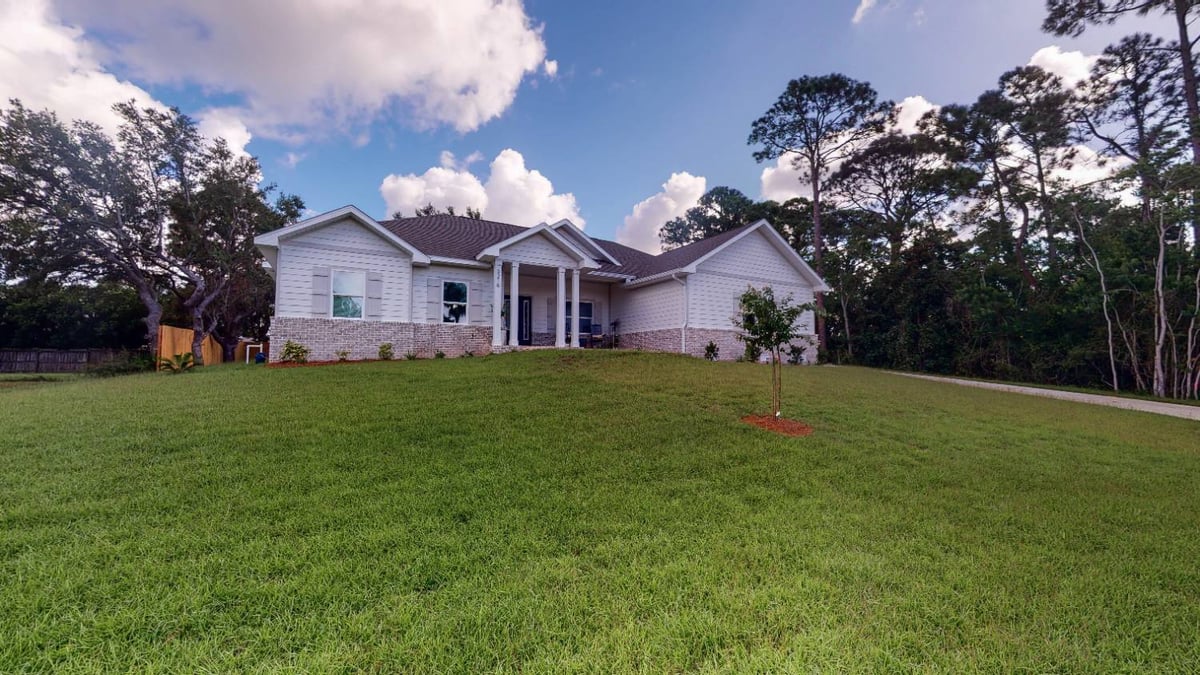 Front view of The Lafon custom home by EZ Modern Homes with landscaped yard in Pensacola, FL-optimized