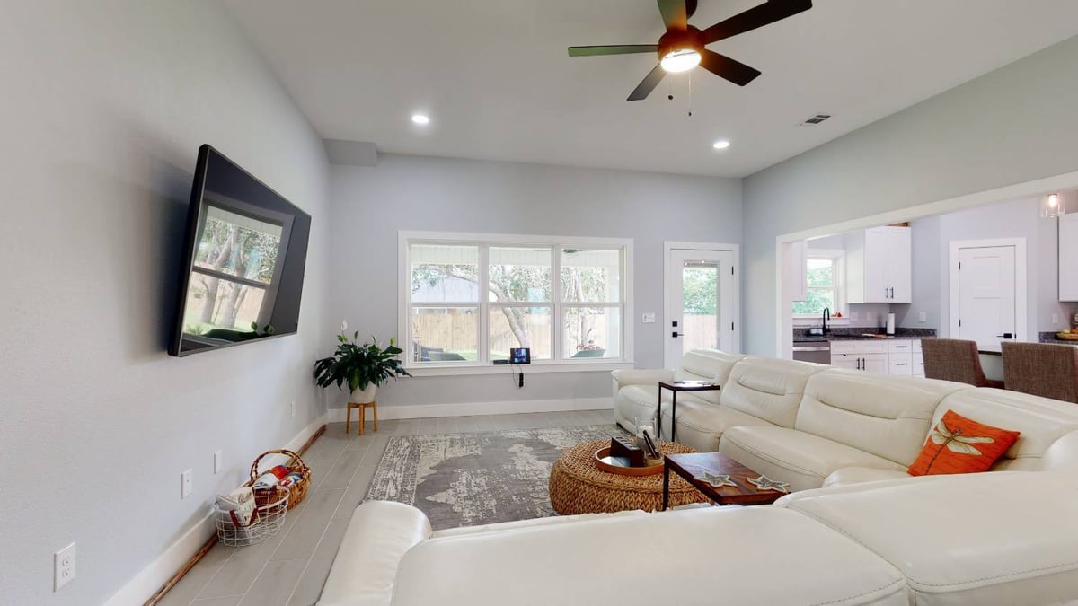 Living room in EZ Modern Homes The Lafon custom home with large windows and sectional sofa in Pensacola, FL-optimized
