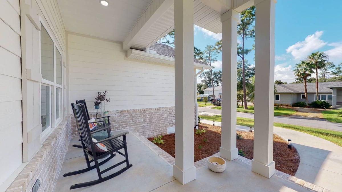 Side porch view of EZ Modern Homes The Lafon custom home with seating area in Pensacola, FL-optimized