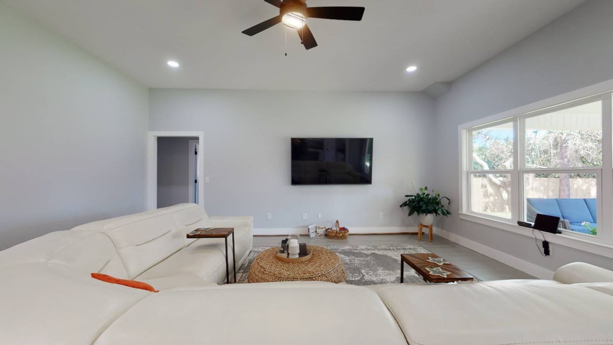 Wide living room view in EZ Modern Homes The Lafon custom home with TV wall and windows in Pensacola, FL-optimized