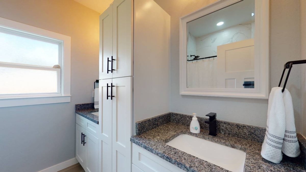 bathroom vanity with storage cabinets and mirror by EZ Modern Homes custom home in Pensacola FL The Lafon-optimized