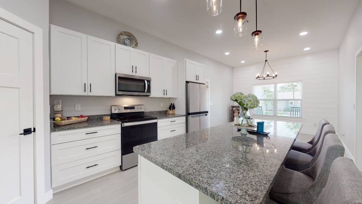 close view of granite kitchen island and white cabinetry in The Lafon custom home by EZ Modern Homes in Pensacola, FL-optimized