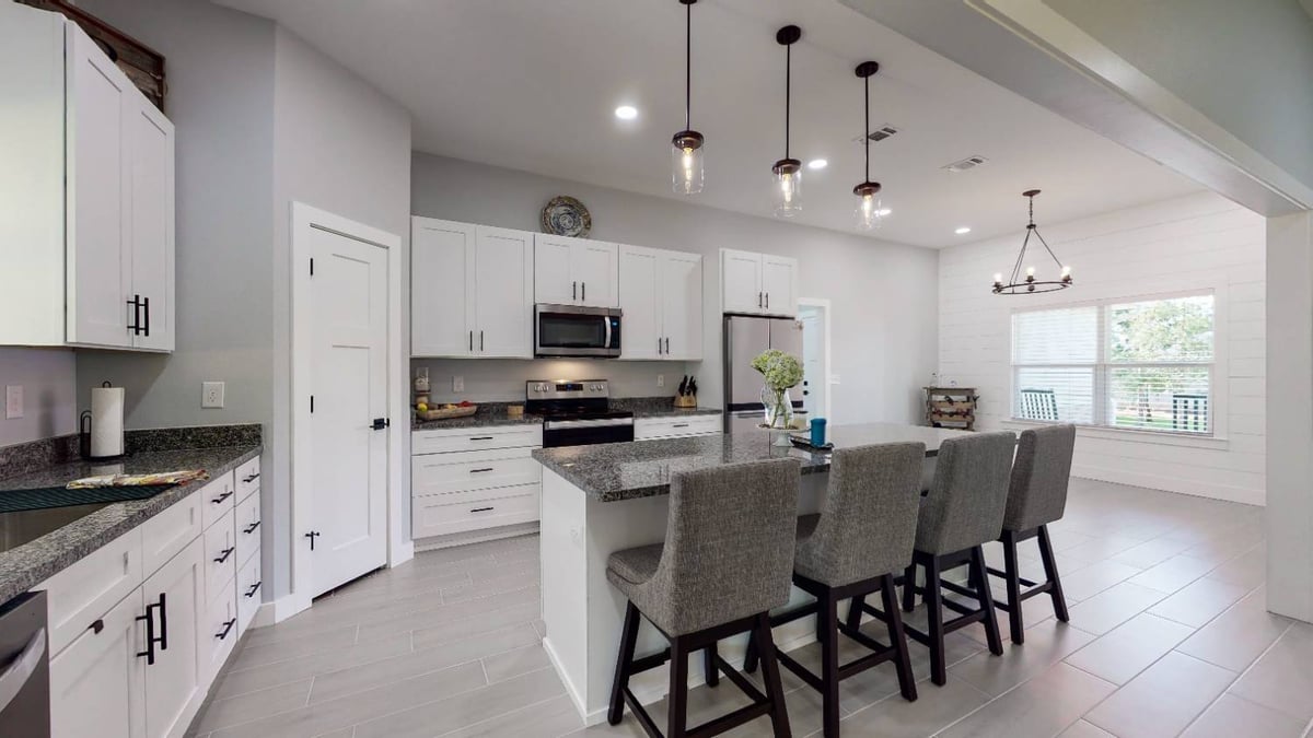 contemporary kitchen with large island and bar seating in The Lafon custom home by EZ Modern Homes in Pensacola, FL-optimized
