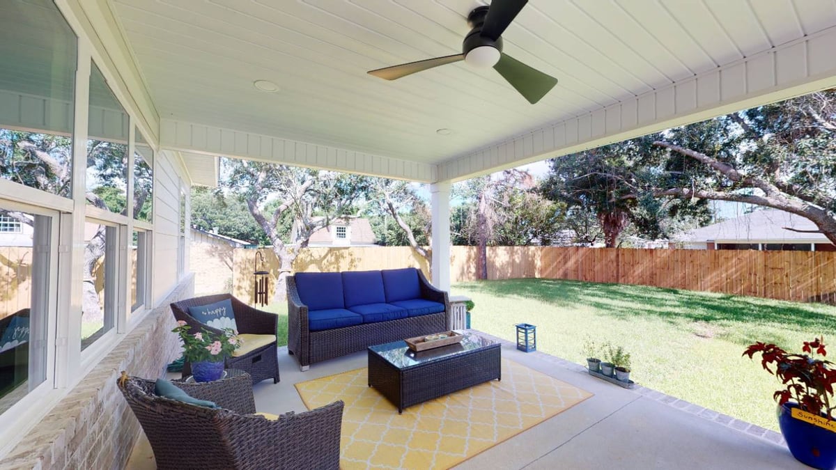 covered backyard patio with outdoor seating and ceiling fan by EZ Modern Homes custom home builder in Pensacola FL The Lafon-optimized