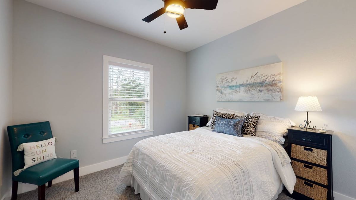 cozy bedroom with neutral decor and ceiling fan by EZ Modern Homes custom home in Pensacola FL The Lafon-optimized