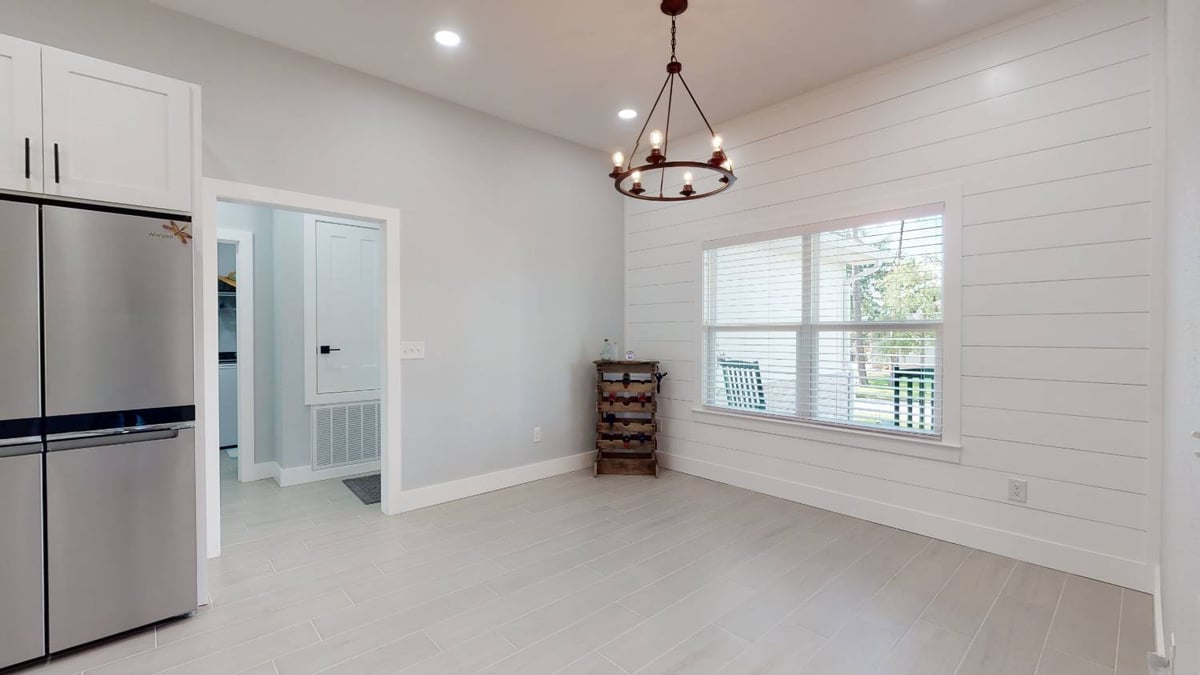 dining area with chandelier and window view in The Lafon custom home by EZ Modern Homes in Pensacola, FL-optimized