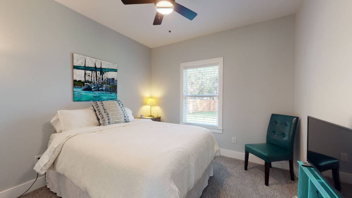guest bedroom with bed and wall art by EZ Modern Homes custom home in Pensacola FL The Lafon-optimized