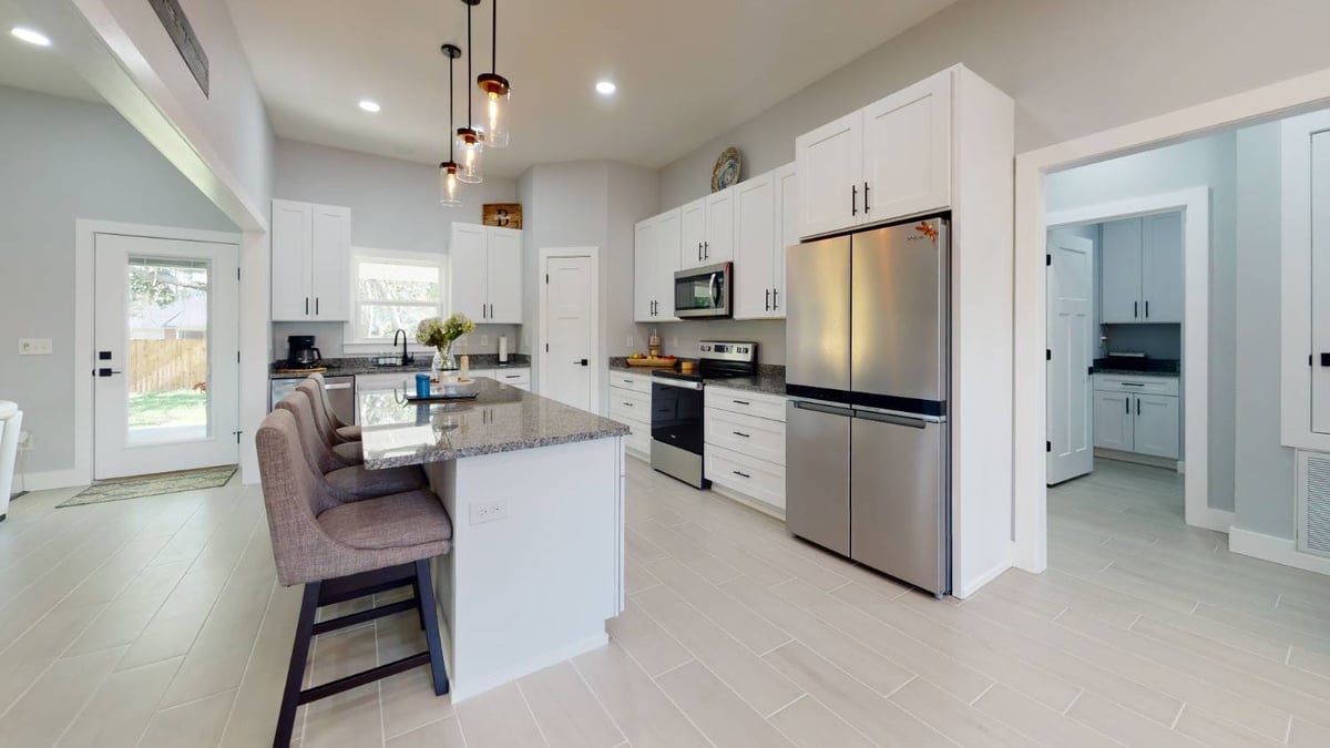 kitchen and dining area with wine rack accent in The Lafon custom home by EZ Modern Homes in Pensacola, FL-optimized