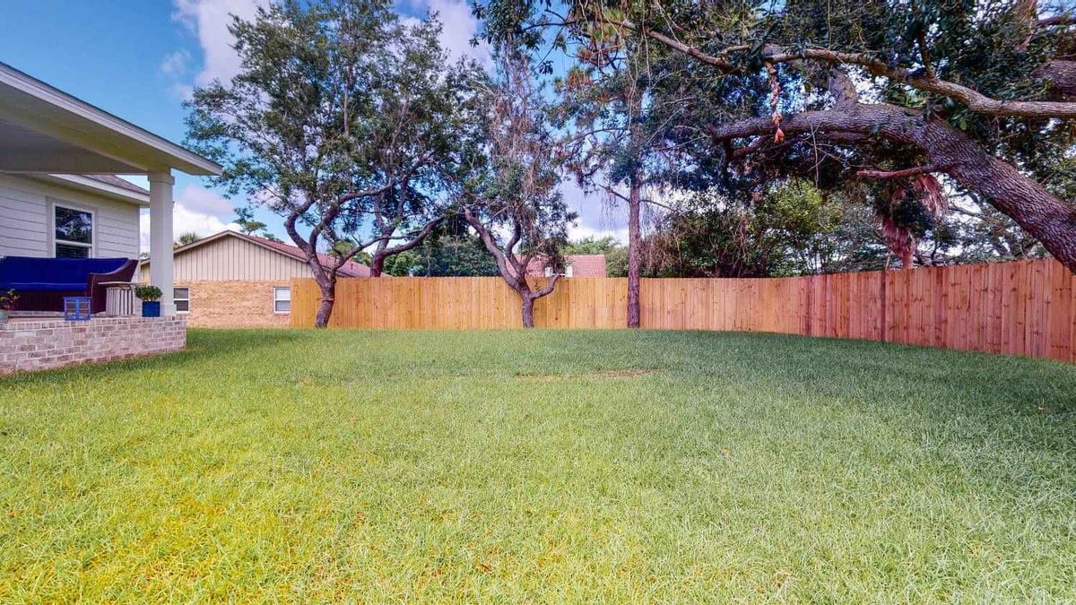 spacious backyard with trees and wood privacy fence by EZ Modern Homes custom home in Pensacola FL The Lafon-optimized