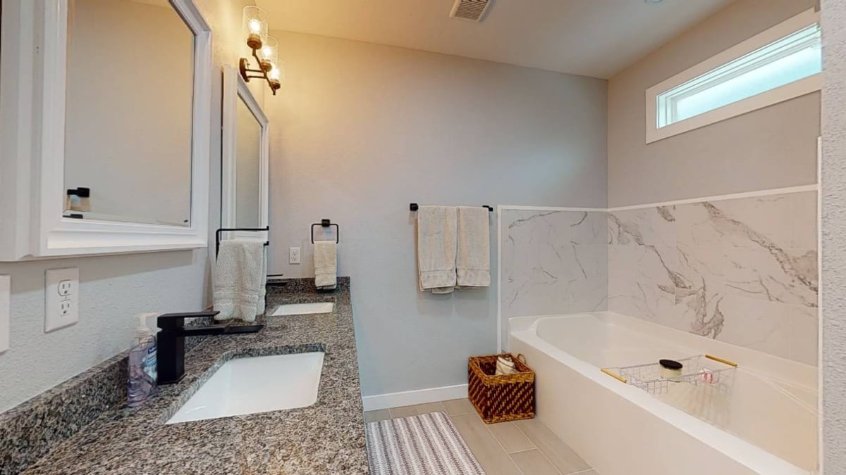 spacious bathroom with soaking tub and dual vanity by EZ Modern Homes custom home in Pensacola FL The Lafon-optimized