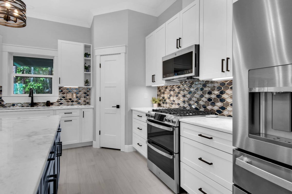 Close-up of stove area with patterned backsplash in The Lafon custom home by EZ Modern Homes Pensacola, FL-optimized